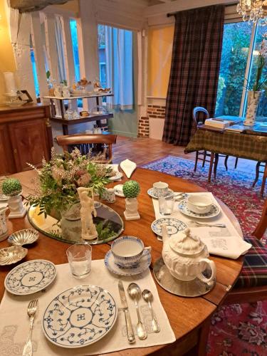 a table with blue and white dishes on it at Le Logis Fleurs et jardins de Pitry in Thierville