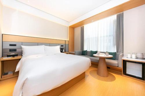 南京的住宿－Ji Hotel Nanjing Confucius Temple Sanshan Street，卧室配有一张白色大床和电视。