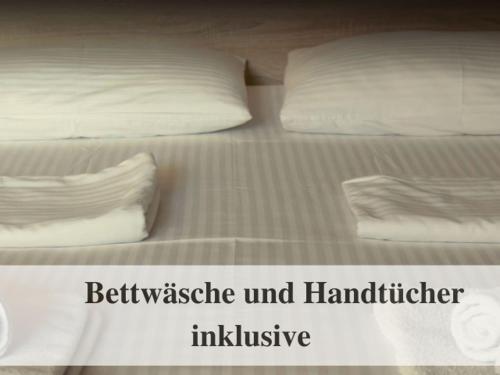 un letto con lenzuola bianche e 2 cuscini sopra di Waldstrandnest mit Weitblick a Timmendorfer Strand