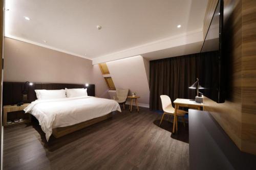 Un pat sau paturi într-o cameră la Hanting Premium Hotel Youjia Shanghai Xinzhuang Chang Dong Road