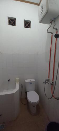 een badkamer met een toilet en een bad bij Hotel Purnama 5 in Ngaglik