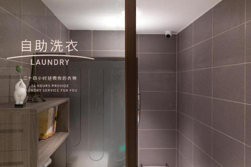 y baño con ducha y paredes de azulejos grises. en Hanting Hotel Nanjing Fuzimiao Scenic Spot en Kao-ch'iao