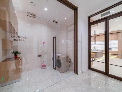 bagno con doccia in vetro in un edificio di Hanting Premium Hotel Youjia Wuhan Etouwan Metro Station a Wujiashan