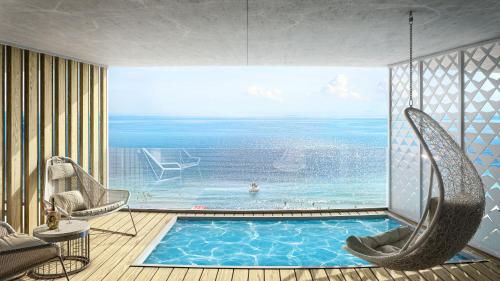 een kamer met een zwembad en uitzicht op de oceaan bij GRIFID Noa - Premium Ultra All Inclusive in Goudstrand