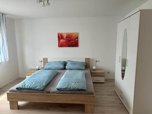 Un dormitorio con una cama con almohadas azules. en Wohnung in idyllischer Lage en Ammerbuch