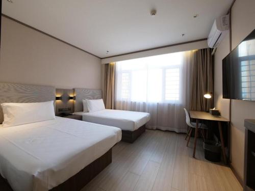 Łóżko lub łóżka w pokoju w obiekcie Hanting Hotel Ulan Qab Jining Normal University