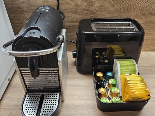 un grille-pain assis sur une table à côté d'un récipient de boutons dans l'établissement CosyNook - refait à neuf proche parc des expositions et aéroport CDG - Parking privé gratuit, à Villepinte