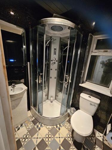 uma casa de banho com um chuveiro, um WC e um lavatório. em Tamarind Cove & Barrons Hotel em Blackpool