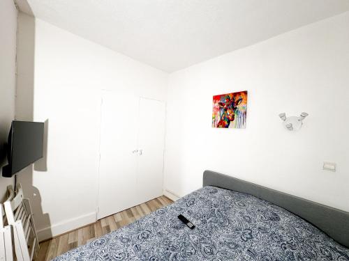 une chambre avec un lit et un tableau au mur dans l'établissement Studio St Ursule R1, à Montpellier