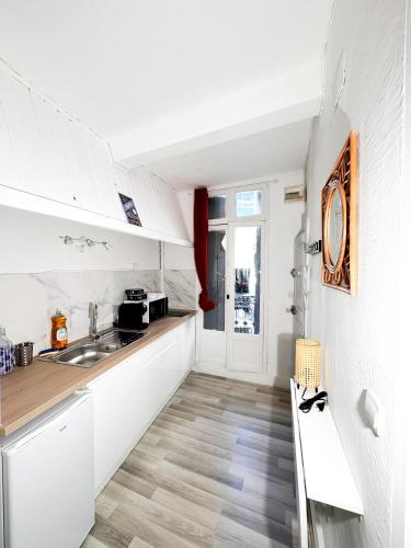 une cuisine avec des armoires blanches et un évier dans l'établissement Studio St Ursule R1, à Montpellier