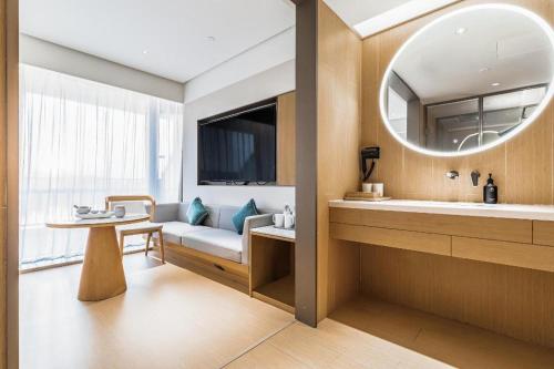 a bathroom with a couch and a table and a mirror at Ji Hotel Nanjing Xianlin Center in Dongchanglin