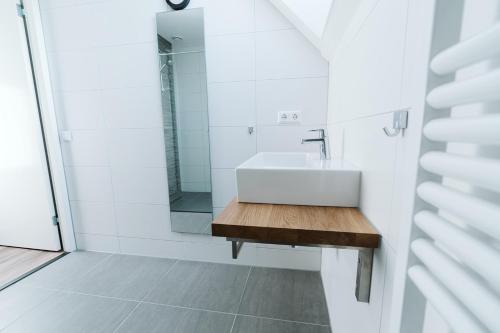 a white bathroom with a sink and a mirror at Ridderstee Ouddorp Duin in Ouddorp