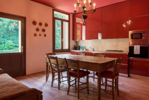 a kitchen with red cabinets and a wooden table and chairs at Castello di Lispida in Monselice