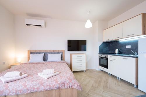 a bedroom with a large bed and a kitchen at WOW studios for rent - bul Montevideo 25A - B in Sofia