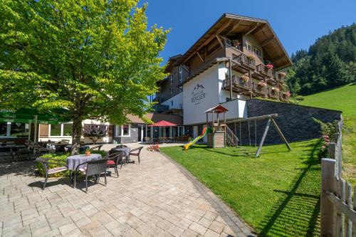 ein Hotel mit einem Spielplatz vor einem Gebäude in der Unterkunft Landhotel Berger in Eben im Pongau