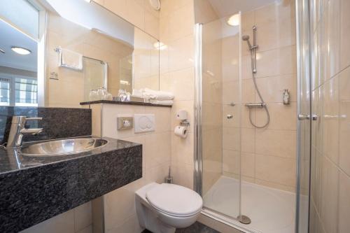 a bathroom with a toilet and a shower and a sink at Fletcher Hotel-Restaurant Arneville-Middelburg in Middelburg