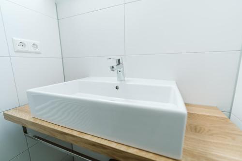 a bathroom with a white sink on a wooden counter at Ridderstee Ouddorp Duin in Ouddorp
