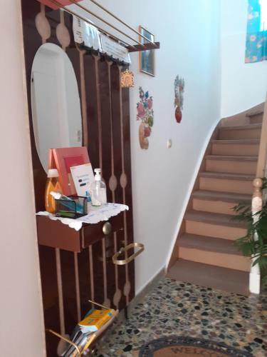 a hallway with a staircase with a mirror and a table at THALIA'S GARDEN in Mytilini