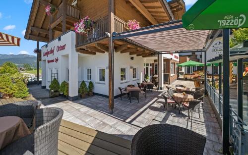 a patio with tables and chairs on a building at Landhotel Berger in Eben im Pongau