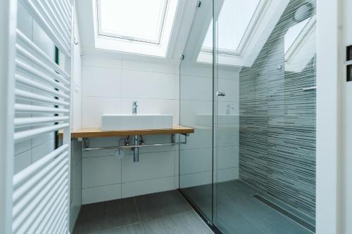 a bathroom with a sink and a glass shower at Ridderstee Ouddorp Duin in Ouddorp