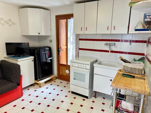 a kitchen with a stove and a sink and a refrigerator at Cozy Chalet With Mountain Views in Ussin, Valtourneche, Parking in Chamois