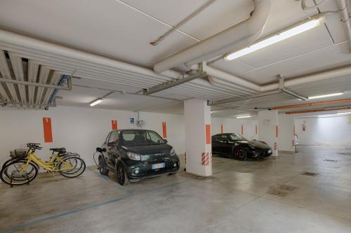 a parking garage with two cars and a bike at Hotel Fontana Verona in Verona