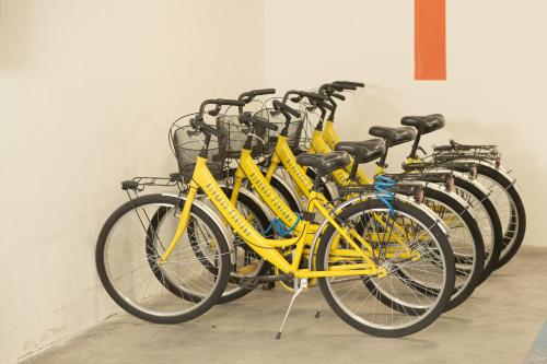 a row of yellow bikes parked next to a wall at Hotel Fontana Verona in Verona