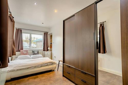 a bedroom with a bed and a large wooden closet at Promotion, Half Price 1 Bed Flat By Richmond Park in London