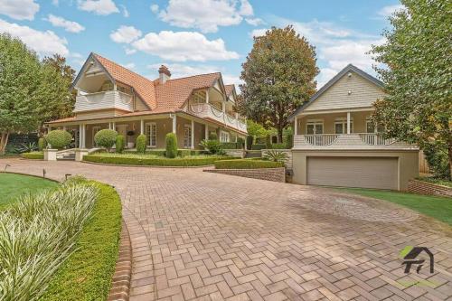 a large house with a brick driveway in front of it at 'Lynwood' Warrawee Manor- Koi Home in Warrawee