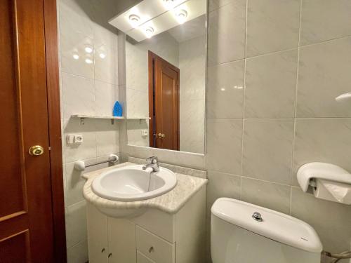ein Badezimmer mit einem Waschbecken, einem WC und einem Spiegel in der Unterkunft Costa Daurada Apartaments - LA SIRENA in Salou
