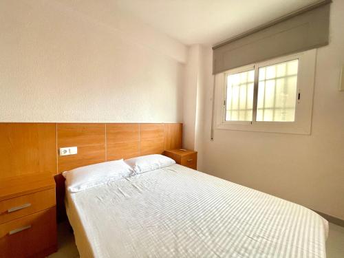 Schlafzimmer mit einem weißen Bett und einem Fenster in der Unterkunft Costa Daurada Apartaments - LA SIRENA in Salou