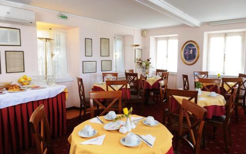 a dining room with tables and chairs with yellow tablecloths at Konstantinoupolis in Corfu