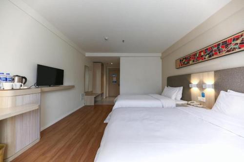 Uma cama ou camas num quarto em Hanting Hotel Guiyang Huaguoyuan Twin Towers