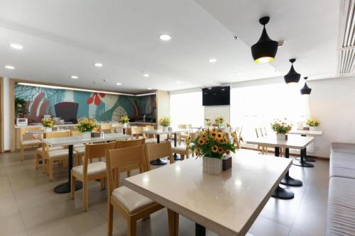 a restaurant with tables and chairs and a cafeteria at Hanting Hotel Guiyang Huaguoyuan Twin Towers in Sanqiao