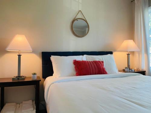 a bedroom with a bed with two lamps and a mirror at Large Renovated Cottage on East Lake Park in Birmingham