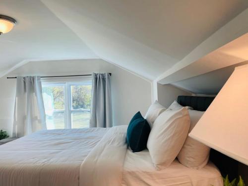 a bedroom with a white bed with a window at Large Renovated Cottage on East Lake Park in Birmingham