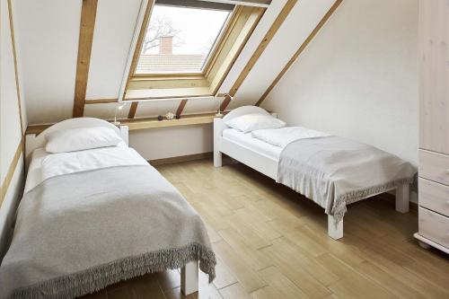 2 Betten in einem Zimmer mit Fenster in der Unterkunft Holunderhaus in Rietz Neuendorf