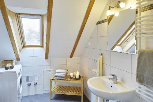 ein Bad mit einem Waschbecken und einem Spiegel in der Unterkunft Holunderhaus in Rietz Neuendorf