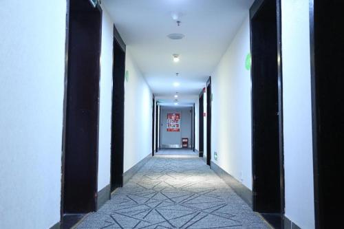 a corridor of a hallway with black columns and white walls at Hi Inn Nanchang Bayi Square Metro Station in Nanchang