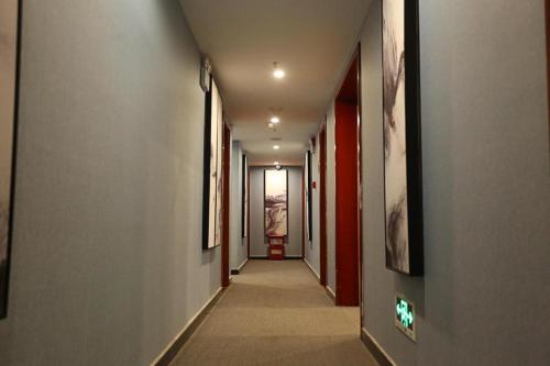 a corridor of a hallway with paintings on the walls at Hi Inn Nanchang Bayi Square Metro Station in Nanchang