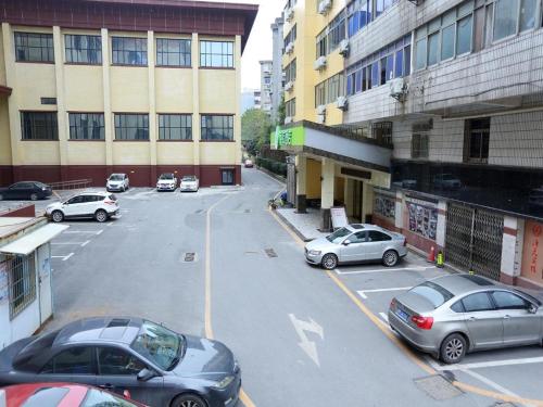 a parking lot with cars parked in front of buildings at Hi Inn Nanchang Bayi Square Metro Station in Nanchang