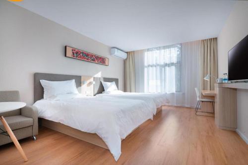 a bedroom with a large white bed and a chair at Hanting Hotel Nanjing Hexi Jiqingmen Street in Nanjing