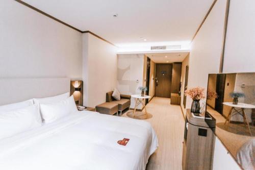um quarto de hotel com uma cama e uma sala de estar em Hanting Hotel Wenzhou Leqing Liushi Town em Hengdaiqiao