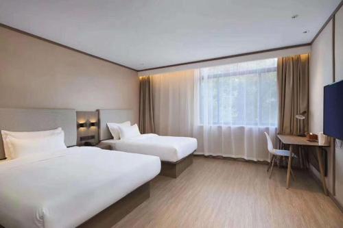 Katil atau katil-katil dalam bilik di Hanting Hotel Xinghua Dainan Jinze Commercial Street
