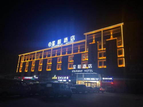 a building with a sign on top of it at night at Starway Hotel Bozhou Yidu International Mall in Bozhou