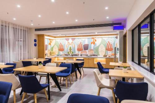 a restaurant with wooden tables and blue chairs at Hanting Hotel Hanzhong Tianhan Avenue Railway Station in Hanzhong