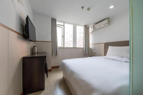 una camera d'albergo con letto e TV di Hi Inn Shanghai Global Harbor a Shanghai