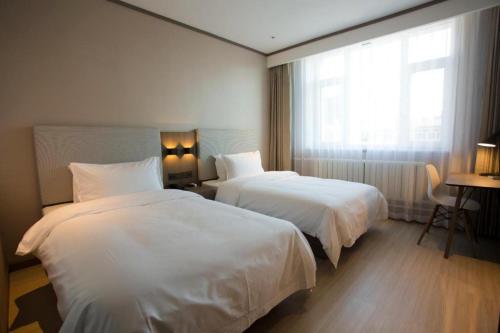 Ein Bett oder Betten in einem Zimmer der Unterkunft Hanting Hotel Jiamusi Guangfu Road