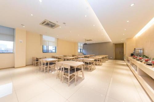 ein Esszimmer mit Tischen und Stühlen in einem Gebäude in der Unterkunft Ji Hotel Ningbo Yinzhou Impression City in Panhuo