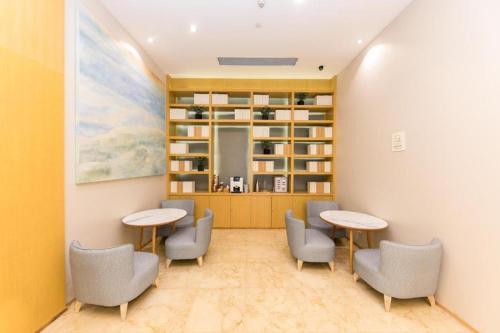 una sala de espera con 2 mesas y sillas en Ji Hotel Ningbo Yinzhou Impression City, en Panhuo